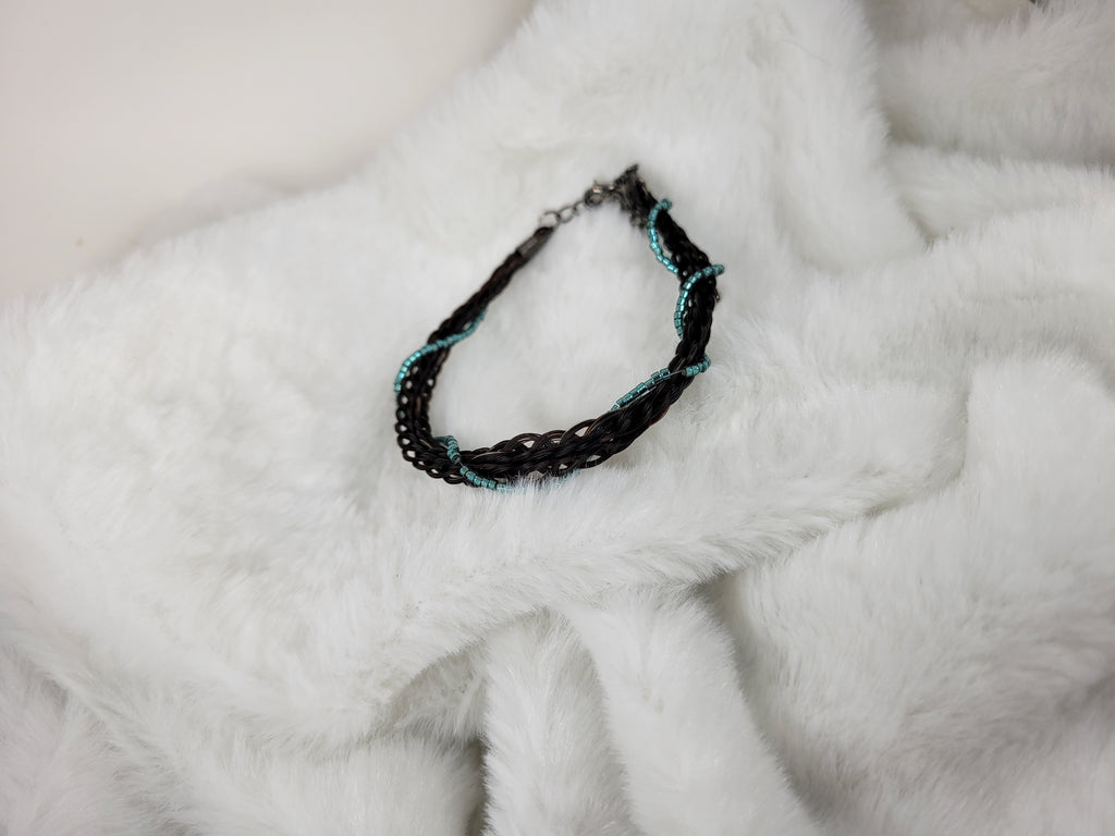 Black and blue beaded necklace on a white fur surface