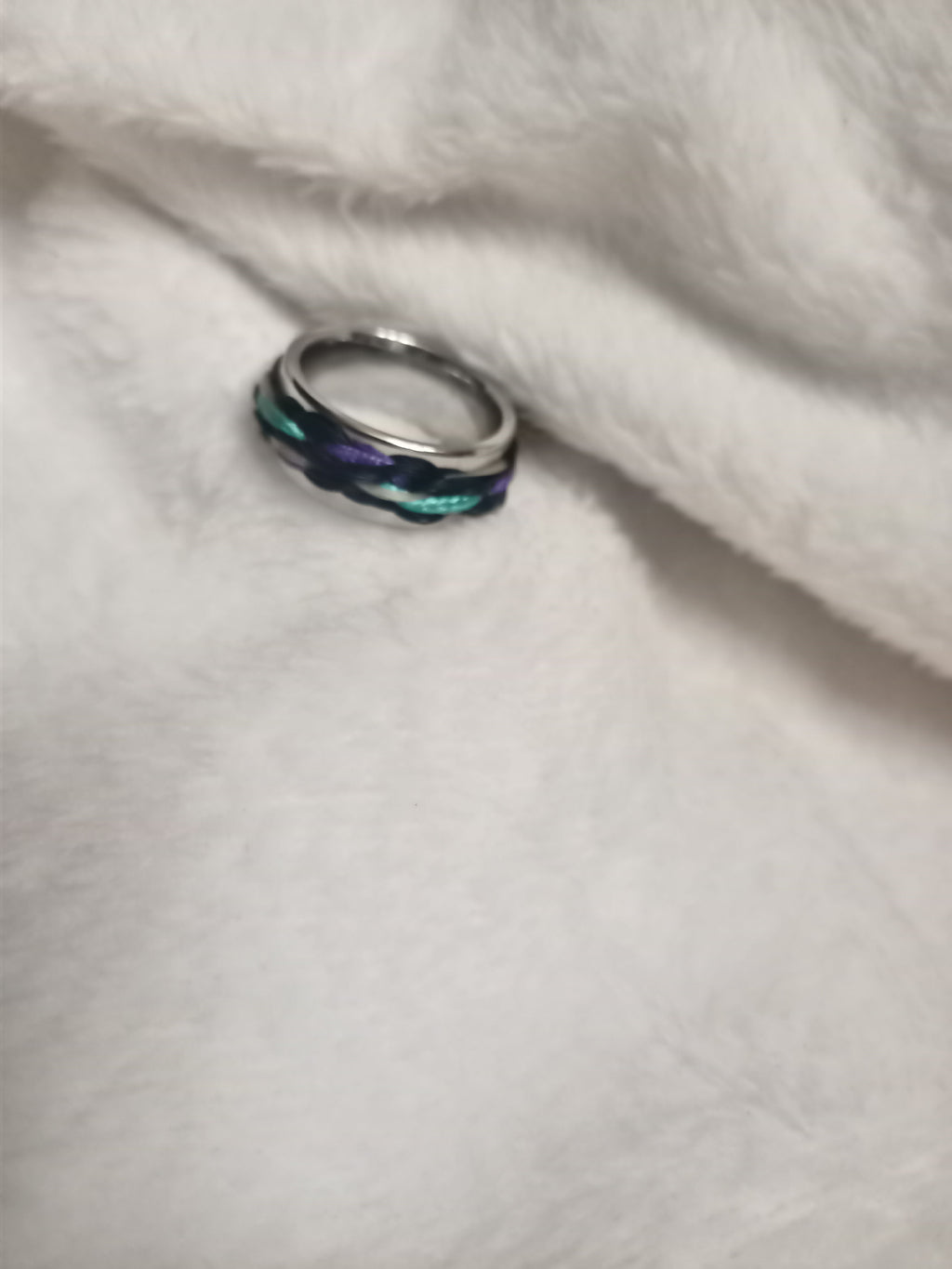 Multicolored ring on a white fabric background