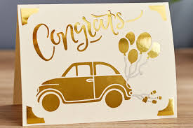 Greeting card with gold car and balloons design on a white background