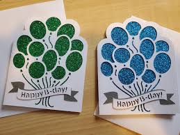 Two greeting cards with balloon designs and 'Happy 18th day' text on a wooden surface.